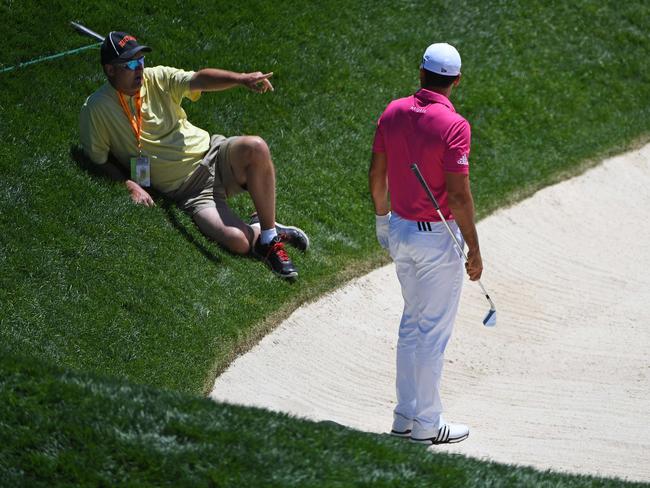 Jason Day looks on as Christopher Crawford's caddie waits for a stretcher.