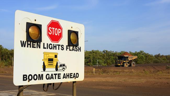 A haul truck drives past a crossing at South32's GEMCO manganese mine.