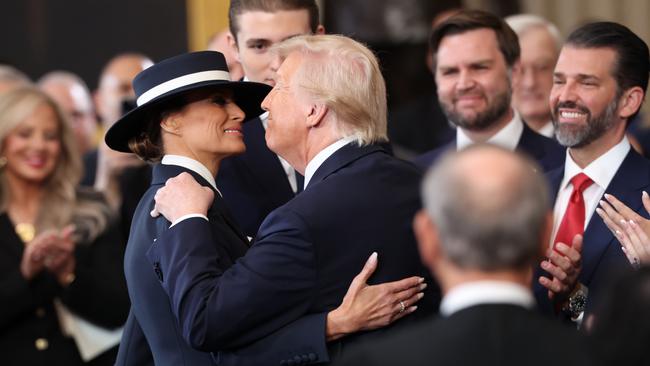 The First Lady’s wide-brimmed hat made it difficult for President Trump to land a kiss. Picture: Getty Images