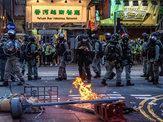 Police walk past a burning barricade set up by protesters during a rally against a new national security law in Hong Kong. Picture: Anthony WALLACE/AFP