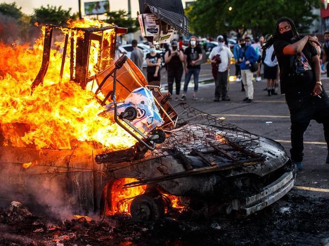 Protesters throw objects into a fire near the Third Police Precinct in Minneapolis, Minnesota. Picture: AFP