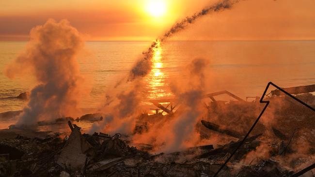 Firefighters douse hot spots from a house reduced to ashes in the Palisades Fire, along the Pacific Coast Highway in Malibu, California. Picture: Cecilia Sanchez / AFP