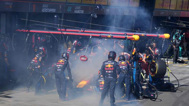 Mechanics deal with the smoke coming out of Red Bull Racing's Dutch driver Max Verstappen. Photo by Scott Barbour / POOL / AFP.