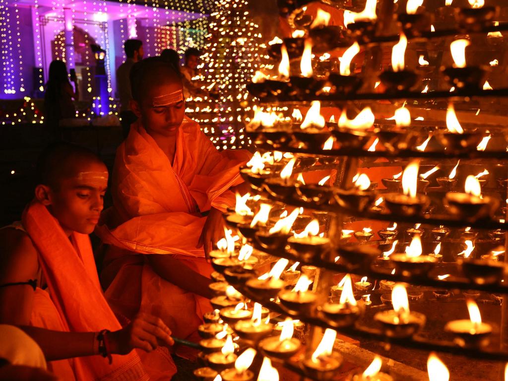 TOPSHOT - Students from a Hindu religious school light earthen lamps in front of Shri Mani Mandir during the celebrations to mark Diwali, the Hindu festival of lights, in Varanasi on October 31, 2024. (Photo by Niharika KULKARNI / AFP)