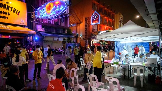 People wait for a free check outside a mobile COVID-19 swab testing site on Khao San Road in the backpacker district of Bangkok, Thailand. Picture: AFP