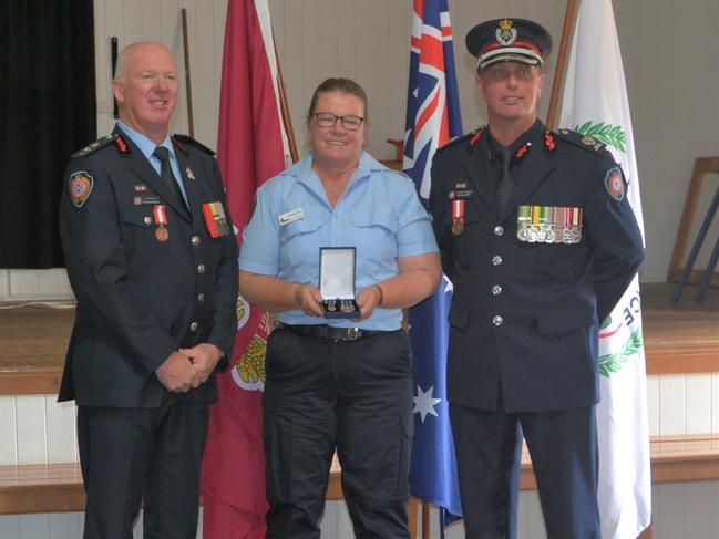 QFES South Western Regional Manager Superintendent Wayne Waltisbuhl (L), Karina Crip and QFES Acting Assistant Commissioner Jason Lawler (R). Sugarloaf Rural Fire Brigade volunteer Karina Crisp was awarded a QFES medal for her dedication to the service as part of the Rural Fire Service Week Awards at Dalveen on Saturday.