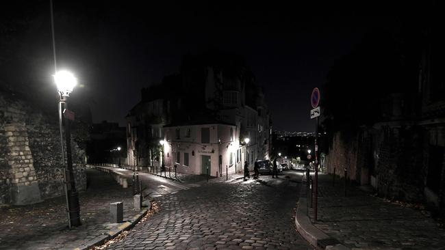 People cross the street past the closed French traditional restaurant La Maison Rose in the Montmartre district on the fourth day of a lockdown aimed at containing the coronavirus spread. Picture: AFP