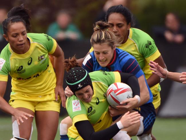 Australia (yellow) vies with France (blue) on the first day of the HSBC World Rugby Women's Sevens Series in Langford, BC, Canada on April 16, 2016. / AFP PHOTO / Don MacKinnon