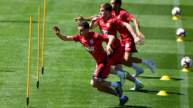 Adelaide players go through their paces at Coopers Stadium yesterday ahead of tonight’s home match against Newcastle. Picture: AAP