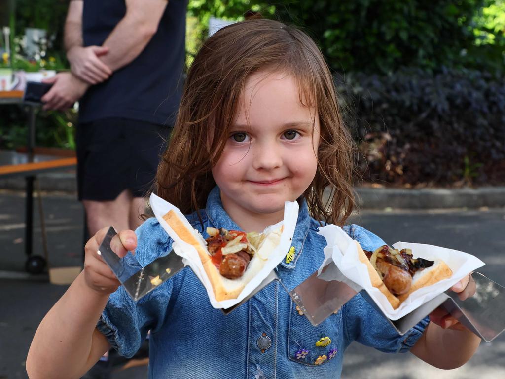 Indie, 4, serves democracy sausages in Bulimba in the Brisbane seat of Griffith as Australians went to the polls to vote in Saturday’s election. Picture: NewsWire/Tertius Pickard