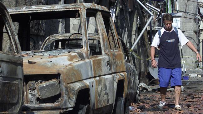 Troy O'Brien from NSW, who injured his foot in the Bali Bombings, picks his way over the debris.