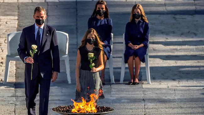 Spanish King Felipe VI, left, and Crown Princess Leonor take roses to a couldron during a state ceremony in Madrid to honour victims of the coronavirus crisis on Thursday. Picture: AFP