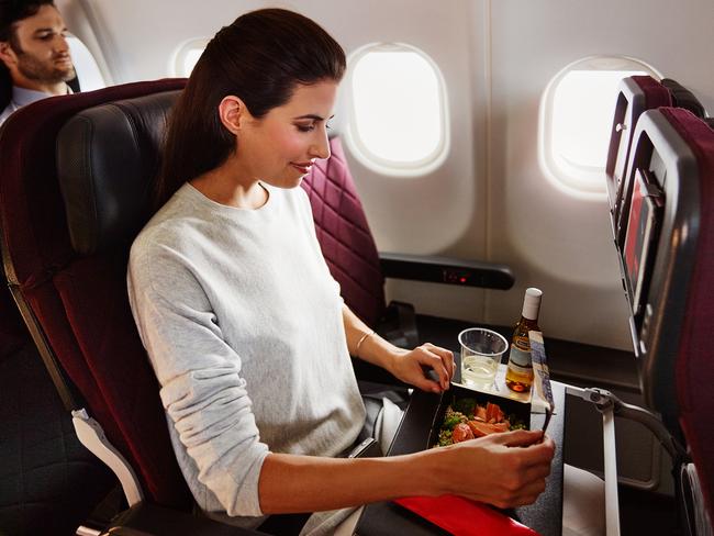 Qantas economy passenger Gabrielle Jervis enjoying a meal on board an A330. Picture: Anson Smart, Brent Winstone