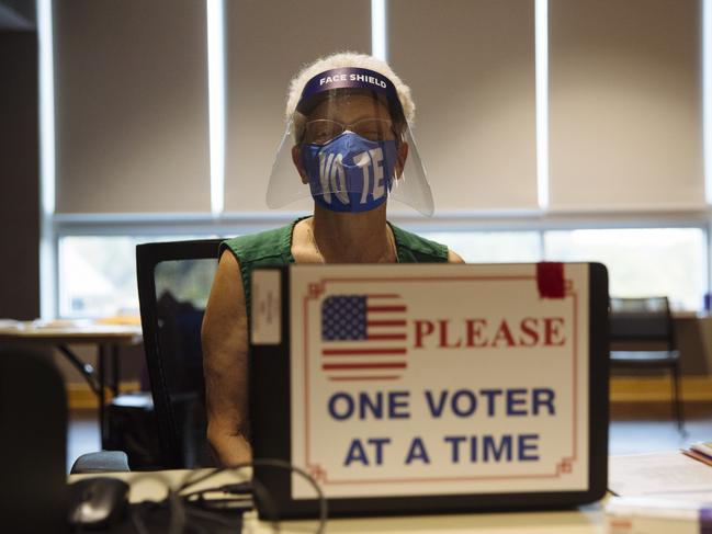 A poll worker for the US Presidential Election wears a facemask emblazoned with the word "Vote" at an early voting location on the University of North Carolina. Picture: Angus Mordant