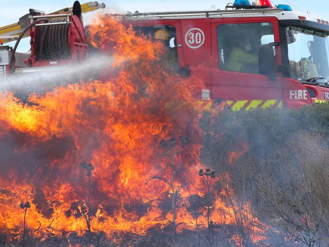 Firefighters at a fast moving grass fire in the Epping area in the northern suburbs of Melbourne, Saturday, Dec 19. 2015. Strong wind gusts up to 80km/h are expected to make firefighters' jobs difficult in dry conditions this weekend. (AAP Image/David Crosling) NO ARCHIVING