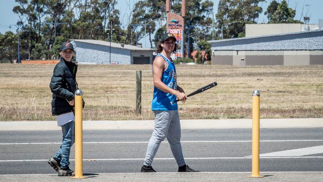 Two youths involved in a stand-off at Wyndham Vale station carry baseball bats. Picture: Jake Nowakowski