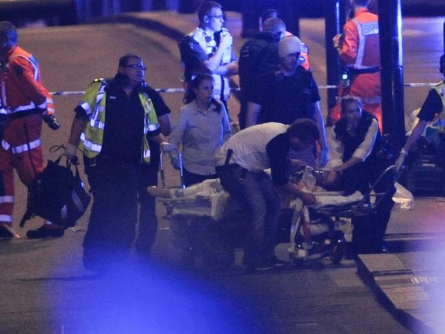 Police officers and members of the emergency services attend to a person injured in a terror attack on London Bridge. Picture: AFP