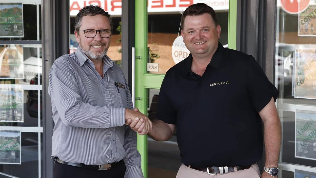 Troy Rogers from One Realty and Billy Mitchell from Century 21 shake hands as they join forces for a new office in Maryborough.