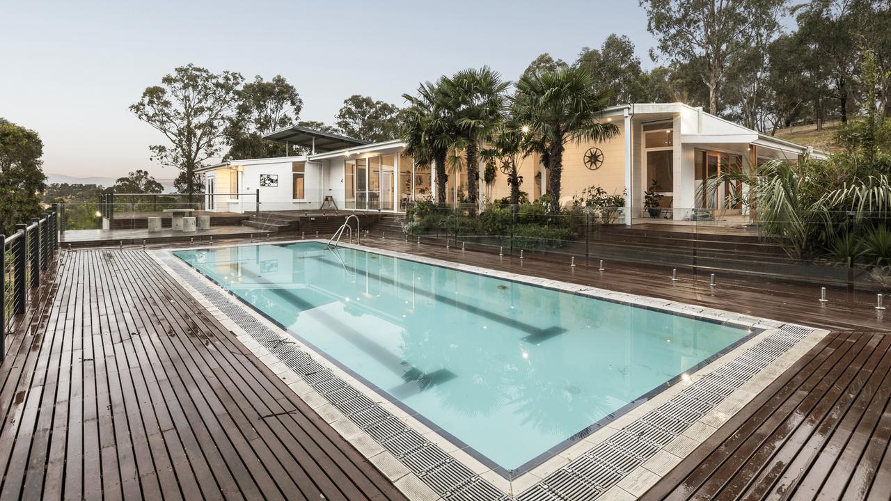 A picturesque place for a dip on a warm day, with a deck surrounding the pool to lounge on.