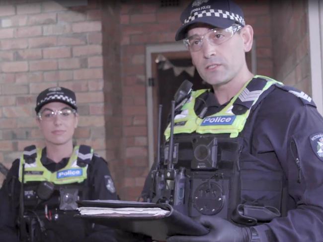 Victoria Police carry out a spot check in Windsor on a person who returned home from overseas last week. Picture: Victoria Police