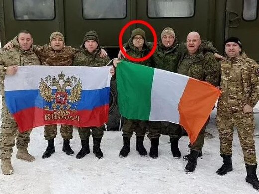 Aiden Minnis (circled) poses with an Irish flag next to troops holding a Russian flag. Picture: Supplied