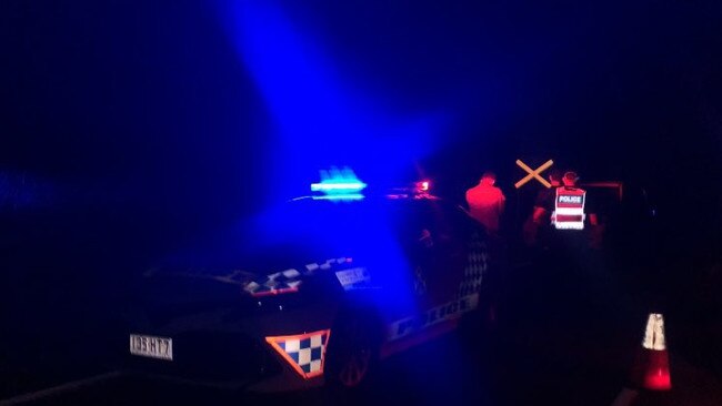 Queensland police and soldiers from the ADF guard the scene of a crash on Hervey Range Rd.