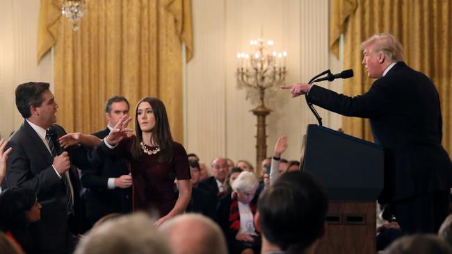 A White House staff member reaches for the microphone held by CNN's Jim Acosta as he questions President Donald Trump during a news conference. Picture: Reuters