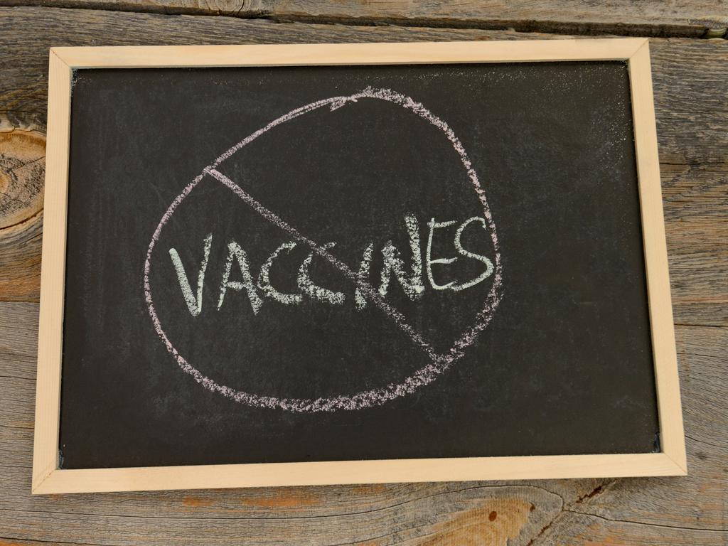 No vaccines written in chalk on a chalkboard on a rustic background