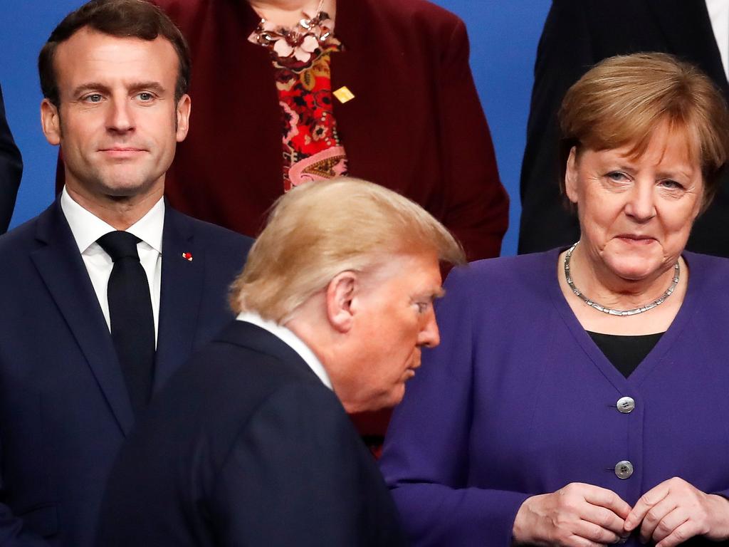 French President Emmanuel Macron (L) and Germany's then Chancellor Angela Merkel (R) look on at US President Donald Trump (C) walking past them during a photo as part of the NATO summit in London, December 2019. Picture: Christian Hartmann/AFP