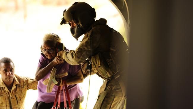 Australian Army soldiers from 51st Battalion, Far North Queensland Regiment, and 5th Aviation Regiment assist a resident to evacuate from Wujal Wujal on 19 December 2023. Picture: Carolyn Barnett, ADF