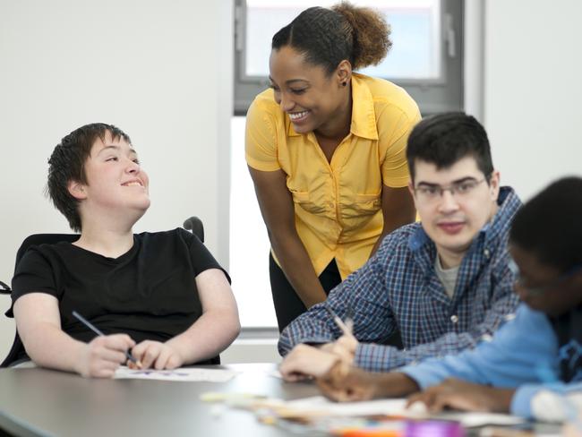 Diverse group of students with disabilities doing arts and crafts.