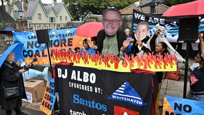 An environmental activist wearing a cardboard cutout showing the face of Prime Minister Anthony Albanese is seen during a protest rally in front of Kirribilli House, in Sydney, on May 8, calling for the Albanese government to halt further approvals of coal and gas projects. Picture: Saeed KHAN / AFP