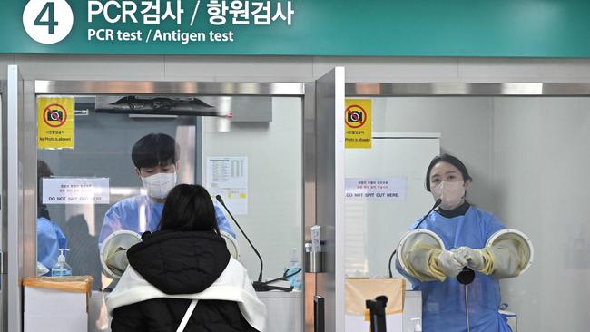 A health worker takes a nasal swab from a traveller arriving from China at a Covid-19. (Photo by Jung Yeon-je / AFP)