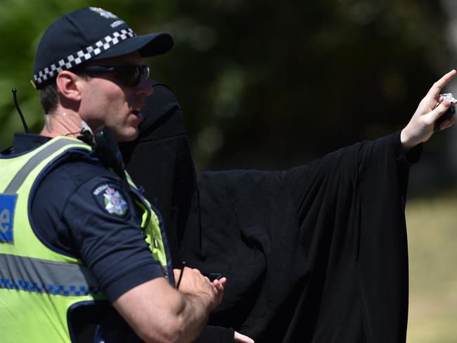 A women wearing a niqab speaks to police near a Meadow Heights property. Picture: Julian Smith/AAP