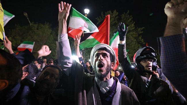 Demonstrators wave Iran's flag and Palestinian flags as they gather in front of the British Embassy in Tehran at the weekend after Iran launched a drone and missile attack on Israel. Picture: AFP