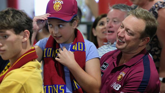 Queensland Premier Steven Miles shares a moment with his daughter Bridie Miles, 10, as they watch the 2024 AFL grand final match between the Brisbane Lions and the Sydney Swans at Cazalys Sports Club, Cairns. Picture: Brendan Radke