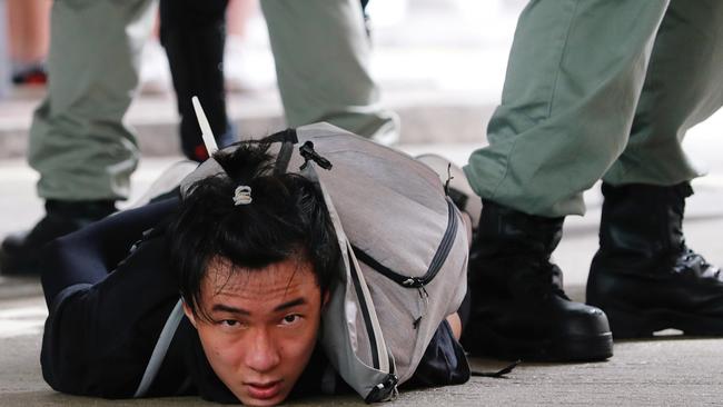 A man lies on the ground as he is detained by riot police during a march against the national security law at the anniversary of Hong Kong's handover to China from Britain in Hong Kong. Picture: Reuters