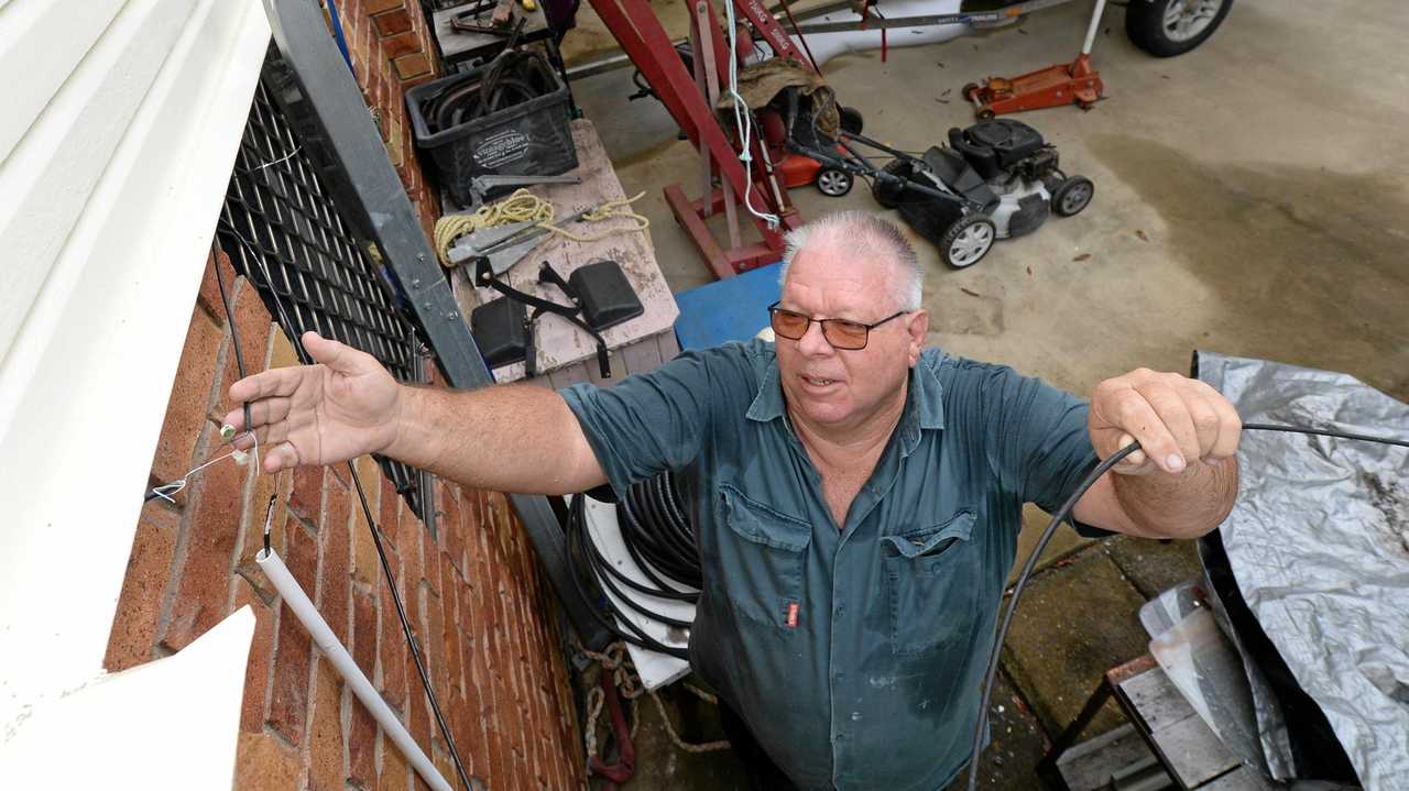 FRUSTING SITUATION: Jeff Beal displays the dodgy wiring going into his property from the stop gap measure to fix his phone line. Picture: Chris Ison ROK020218cline1