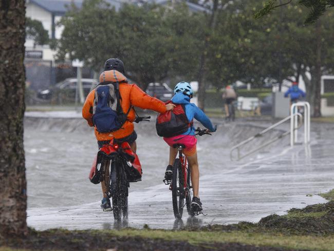 BRISBANE, AUSTRALIA - NewsWire Photos December 14, 2020. Cyclists battle the wind on the foreshore in Wynnum after heavy rains and flooding hit Brisbane on Monday morning as a coastal trough and strengthening low over southeast Queensland and northeast New South Wales brought increasing rain, wind and waves. Picture: NCA NewsWire/Tertius Pickard