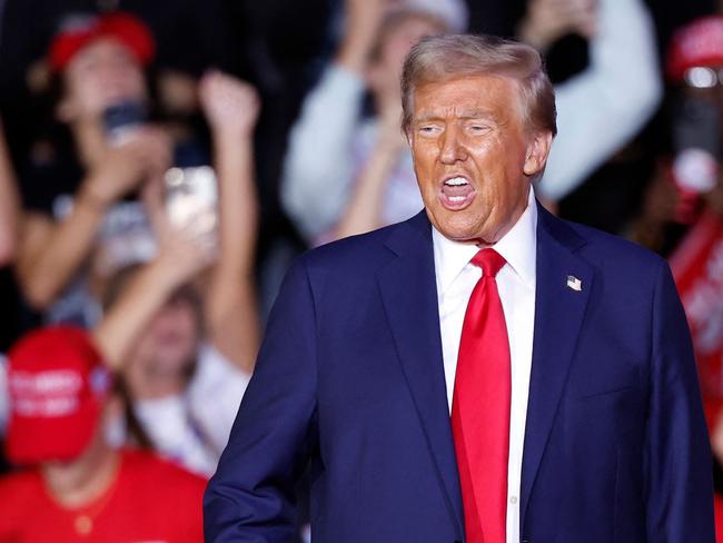 Former US President and Republican presidential candidate Donald Trump gestures as he walks on stage during a campaign rally at Van Andel Arena in Grand Rapids, Michigan on November 5, 2024. (Photo by KAMIL KRZACZYNSKI / AFP)