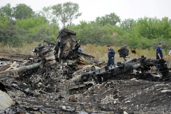 Rescuers stand on July 18, 2014 on the site of the crash of a Malaysian airliner carrying 298 people from Amsterdam to Kuala Lumpur, near the town of Shaktarsk, in rebel-held eastern Ukraine