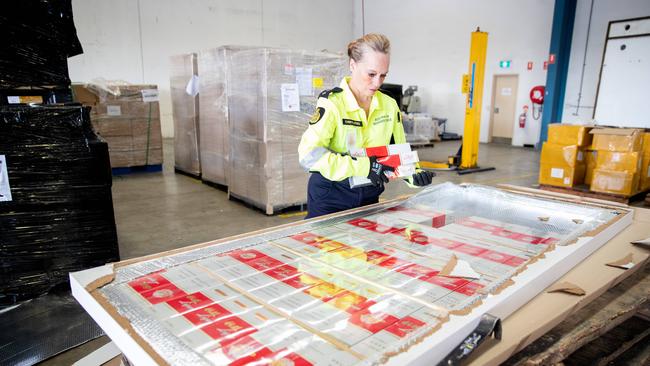 Inspector Cheryl of Strike Force Jardena deconstructs a door filled with illegal cigarettes. Picture Ryan Osland