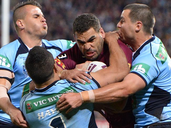 Queensland’s Greg Inglis takes on the NSW defence during game three of the State of Origin series at Suncorp Stadium in Brisbane last night. Picture: Bradley Kanaris/Getty Images