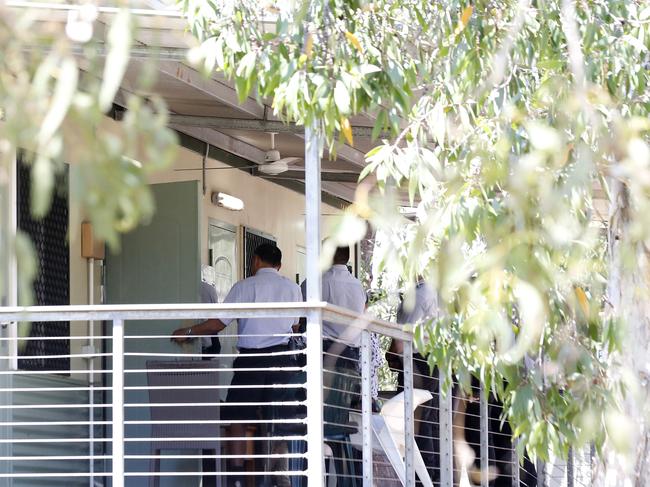 Staff from Serco wait at the door of a secure apartment at Mercure Hotel in Darwin before moving the Tamil family back to airport. Picture: Darrian Traynor/Getty Images.