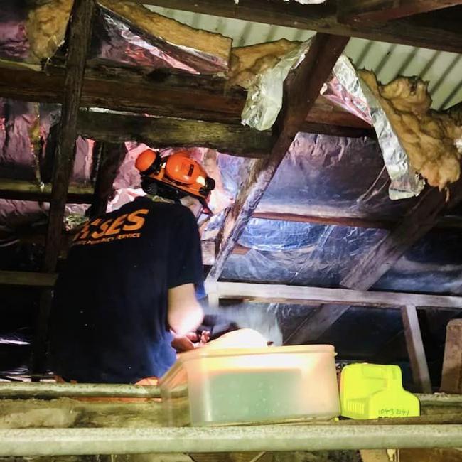 A volunteer from the Manly SES unit works to stop a roof leak at house in High St, Manly, on Friday afternoon. Picture: Manly SES