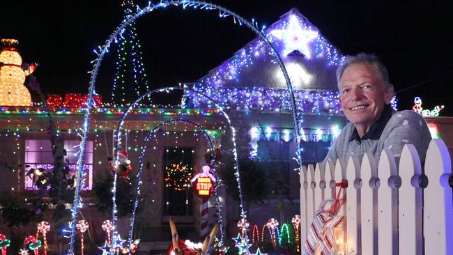 Reg Olson and his granddaughter, Poppy, 18 months, in front of his home with Christmas lights in Ninth St. Picture: AAP/Dean Martin