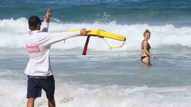 Lifeguards at Surfers Paradise beach keep an eye on beachgoers and keep them swimming between the flags on one of the busiest days of the year. Picture: Glenn Hampson