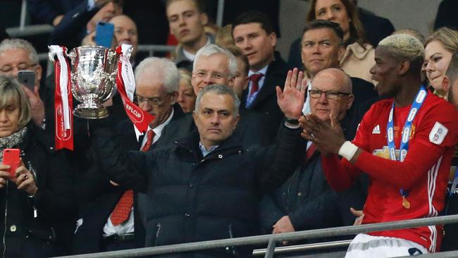 Manchester United's Portuguese manager Jose Mourinho holds up the trophy.