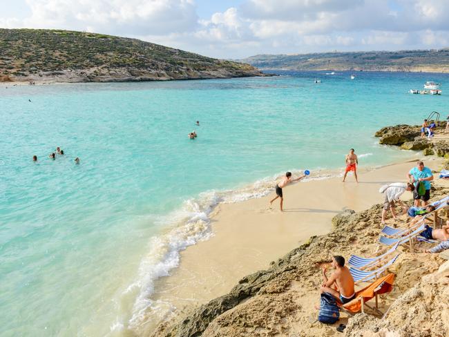ESCAPE:  Comino, Malta - 30 October 2017: people swimming and sunbathing at Blue Lagoon on Comino in Malta Picture: Istock