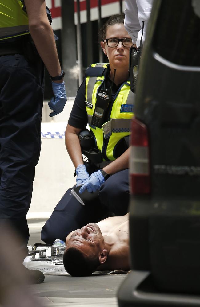 Police with the alleged driver outside 535 Bourke St. Picture: David Caird